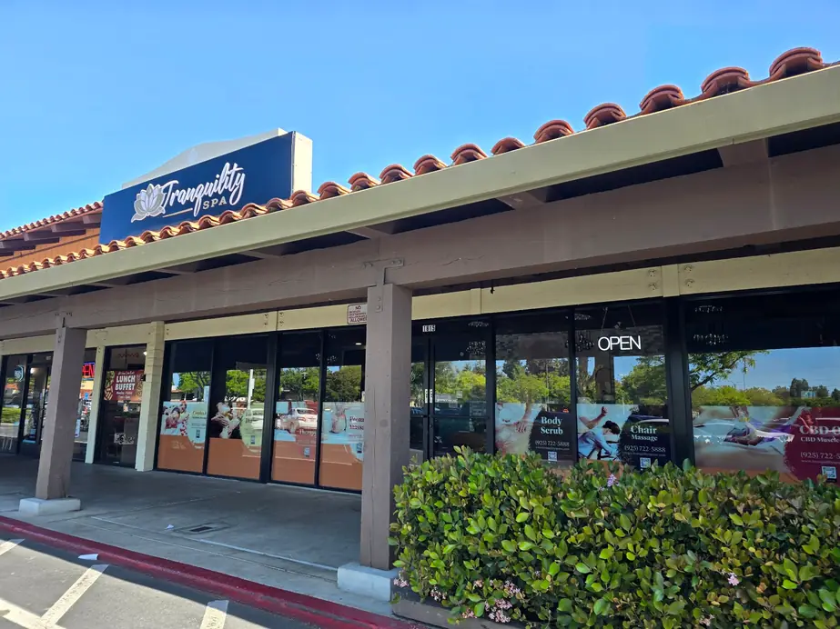 Tranquility Spa frontage in a tiled-roof strip centre on Ygnacio Valley Road, with the lit sign above glass doors and an OPEN sign
